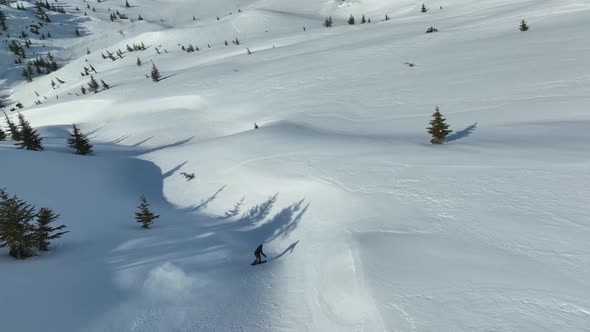 A snowboarder descends from the mountains aerial view 4 K alt