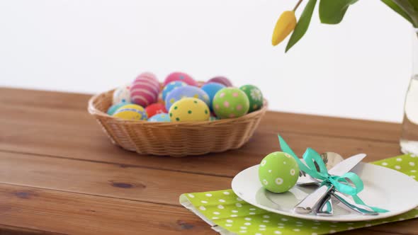 Easter Eggs in Basket and Flowers on Served Table alt