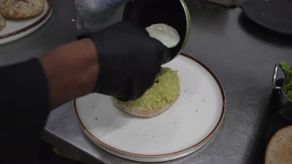 Avocado Egg Sandwich with Whole Grain Bread Served on Plate, Chef Hands alt