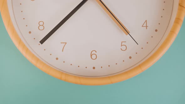 Orange wooden clock in green background -Close up alt