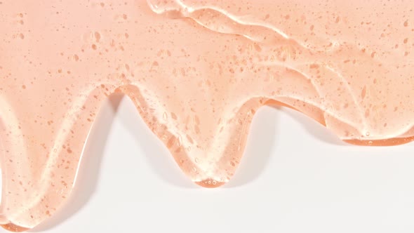 Yellow Transparent Cosmetic Gel Fluid With Molecule Bubbles Flowing On The Plain White Surface alt