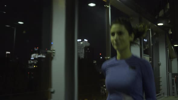 Young adult female jogging in city at night