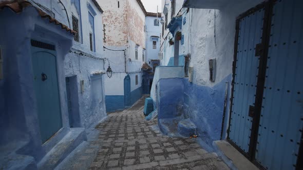 Walking Down Stairs in Narrow Street in Blue City of Chefchaouen alt