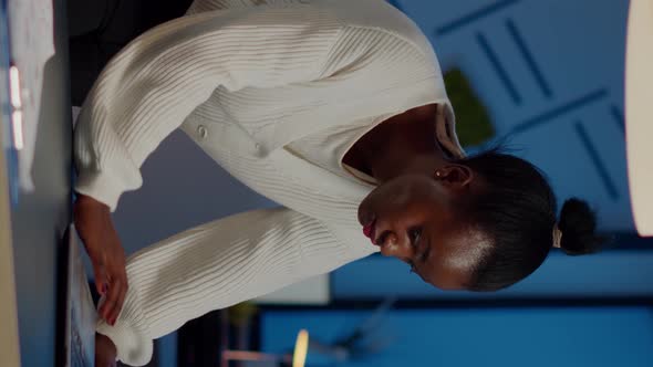 Manager Black Woman Standing at Desk Searching on Laptop and Looking at Camera alt