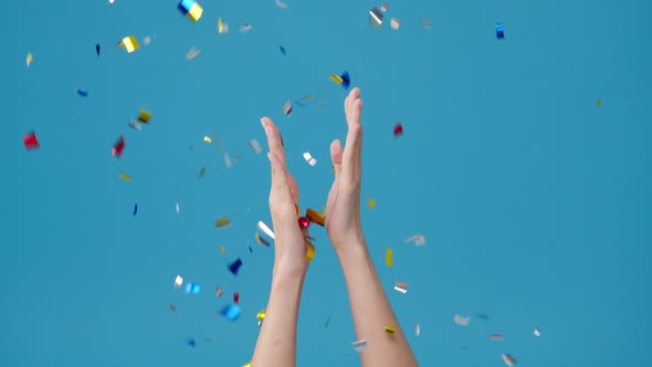 Young girl show hand clapping applause under confetti rain and celebrating over blue background
