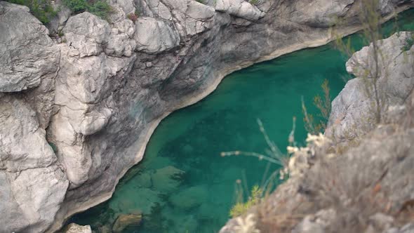 Deep Steep Canyon with Turquoise Water Stream and Rapids alt