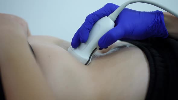 Closeup Hand with Ultrasound Scanner Doing Examination of Female Caucasian Belly Indoors alt