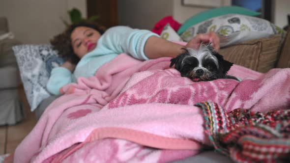 Woman Laying on Sofa with Cute Dog