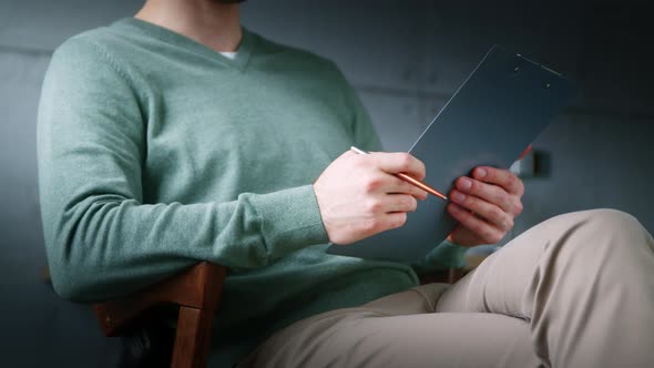 Young professional with clipboard at a psychological session in the office alt
