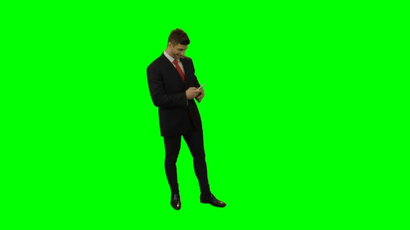 Businessman in suit using mobile phone alt