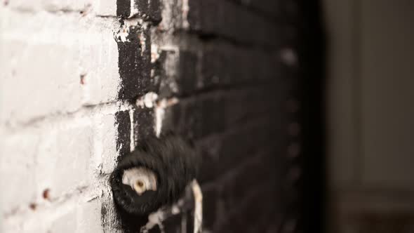Painting Out a Bare Wall with a Paint Roller with Black Paint alt