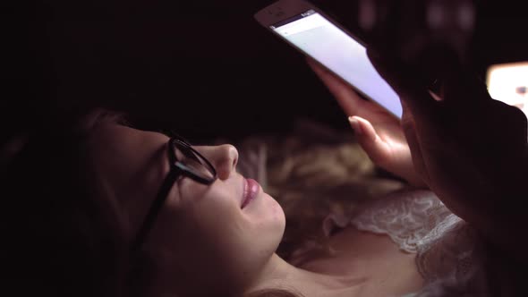 Side View of a Happy Teen Browsing and Watching Media in a Smart Phone Lying on alt