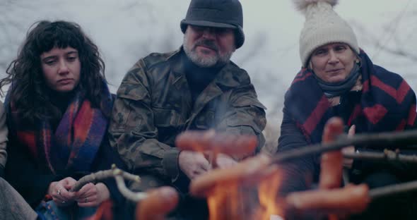 Refugees Roasting Sausages During War Crisis alt