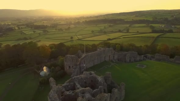 sunrise or sunset flyover of castle ruins alt