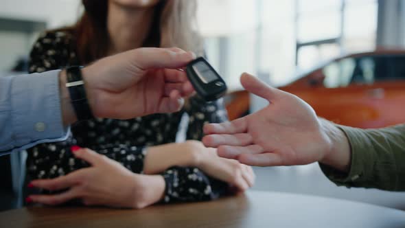 The Dealership Manager Hands Over the Keys to the New Car to the Customer alt