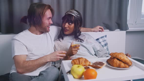 Young Happy Multiracial Couple Having Breakfast in the Bed alt