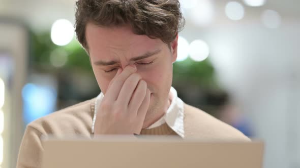 Close Up of Young Male Designer with Laptop Having Headache alt