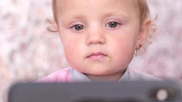 Little Beautiful Girl Watching a Cartoon From the Phone alt