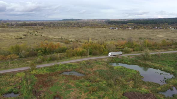 White Semi Truck Driving on Empty Road, Transporting Goods on Sunny Day. Freight Container Truck alt