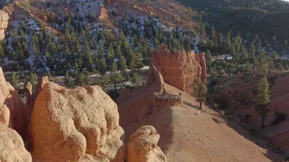 A drone shot of the sandstone rocks of Red Canyon area near Bryce Canyon in the winter and a van is alt