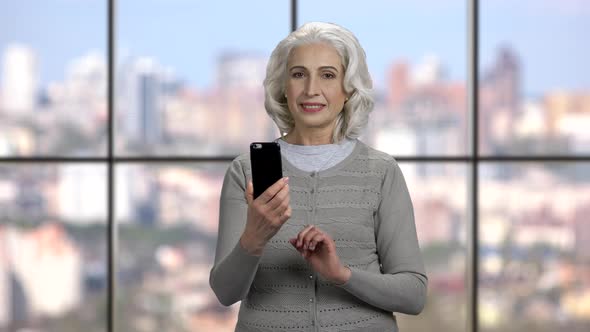 Mature Woman Taking Selfie with Telephone alt