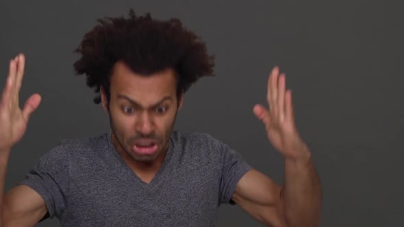 Closeup Dark Skinned Handsome Man Angrily Gesturing and Shouting Isolated on Charcoal Background alt