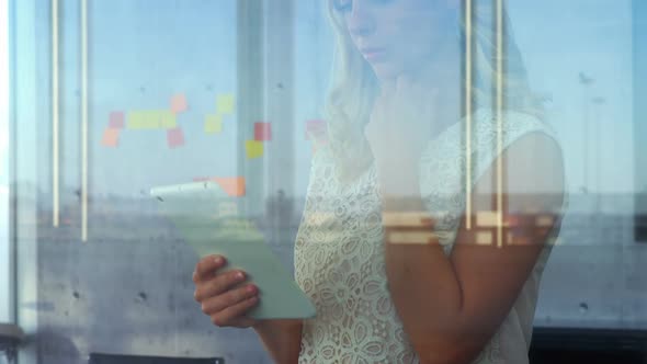 Female executive using a tablet in front of the sticky notes 4K 4k alt