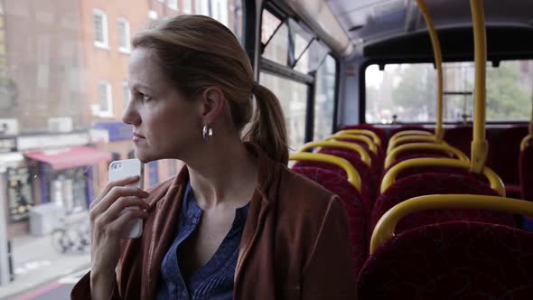 Tired woman sitting in bus, waiting to receive phone call