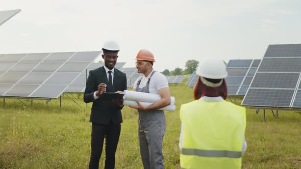 Multiracial People Having Working Discussion About Green Energy While Standing alt