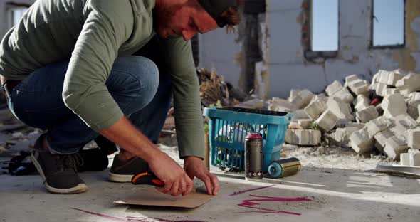 Graffiti artist cutting cardboard with cutter 4k alt