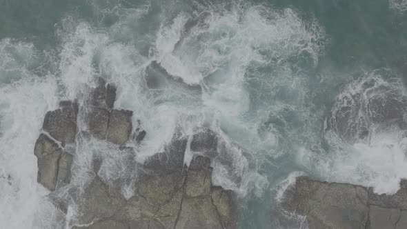 Waves Crash Against Rocks in the Ocean alt