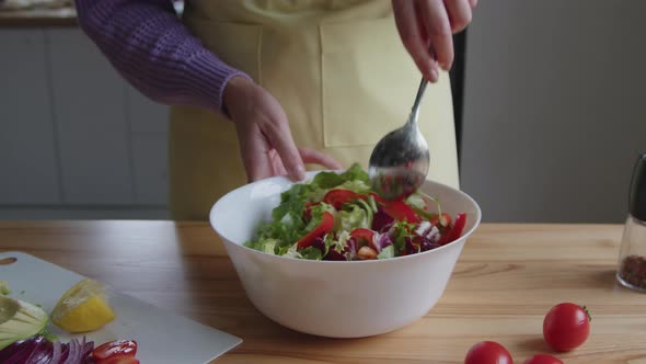 Woman Is Mixing Fresh Salad In Bowl