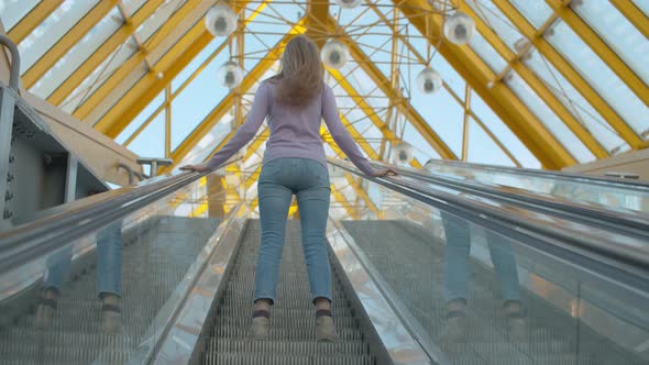 Young Woman Standing on the Escalator alt
