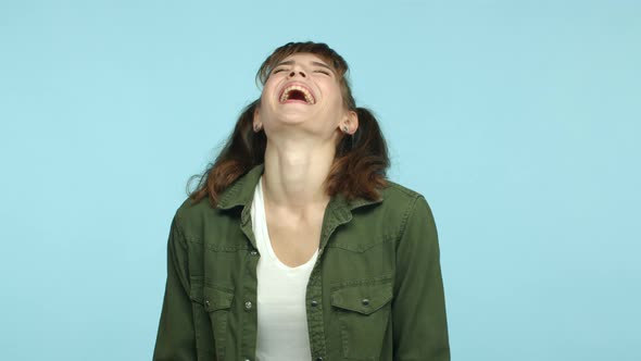 Slow Motion of Young Woman with Two Ponytails Wearing Casual Green Jacket Laughing and Having Fun