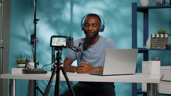 Vlogger Recording Video on Camera with Tripod in Studio alt