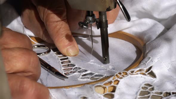An Old Seamstress is Working with a Sewing Machine