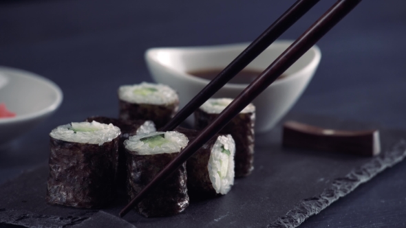 Using Chopsticks To Dip Sushi Into Soy Sauce, Japanese Food
