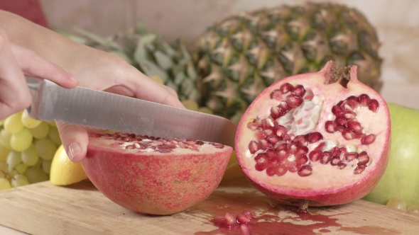 Cuts a Juicy Fruit of Pomegranate