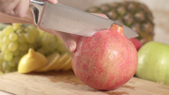 The Cook Cuts the Fruit of Pomegranate