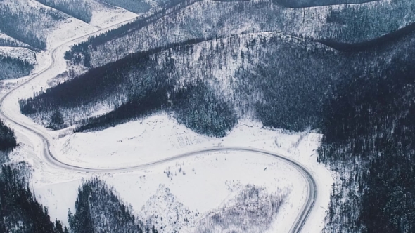 Winter Country Road in Snowy Forest, Aerial View From Drone