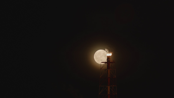Full Moon Moves Behind the Burning Gas of the Rig