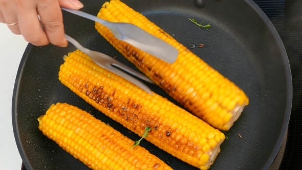 Turn the Cooked Corn Cobs in a Frying Pan
