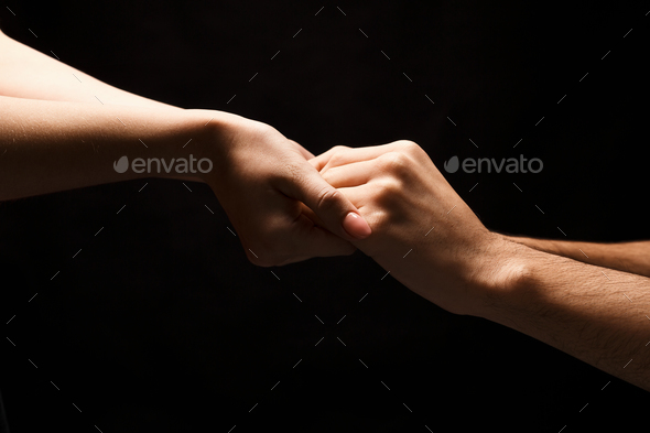 Hands of man and woman in love, isolated on black - Stock Photo - Images