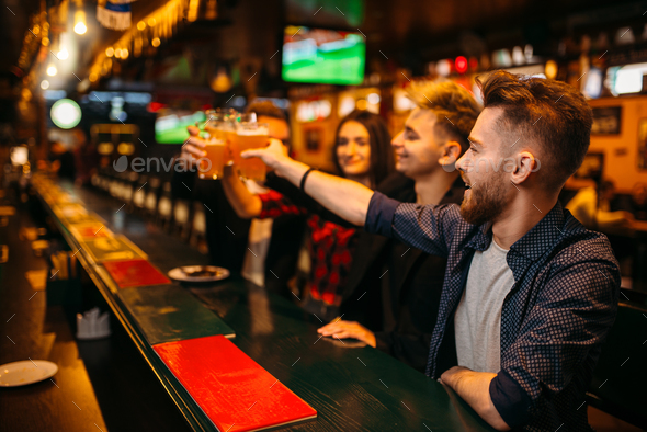 Happy football fans raised their glasses with beer - Stock Photo - Images