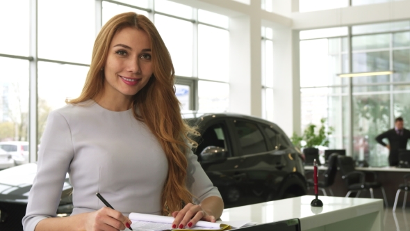 Gorgeous Woman Buying a New Car at the Dealership Smiling To the Camera alt