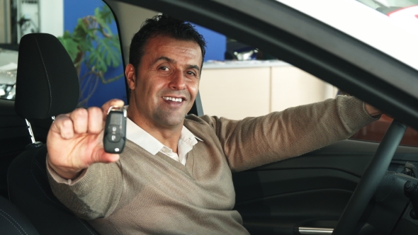 The Satisfied Man Shows the Keys To a New Car alt