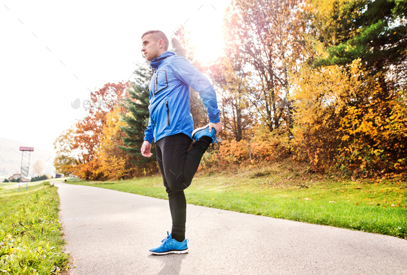 Young runner in autumn park standing on concrete path. - Stock Photo - Images