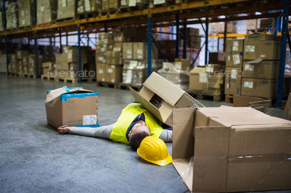 Warehouse worker after an accident in a warehouse. Stock Photo by halfpoint