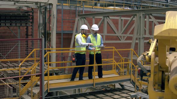 Brick Factory Workers Checking Equipment in a Room alt