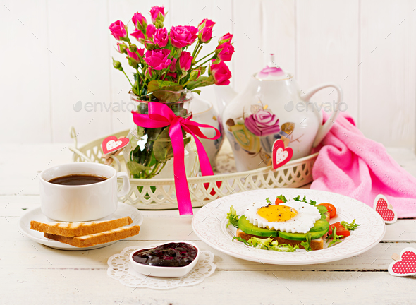 Breakfast on Valentine's Day - fried egg in the shape of a heart, toasts, sausage - Stock Photo - Images